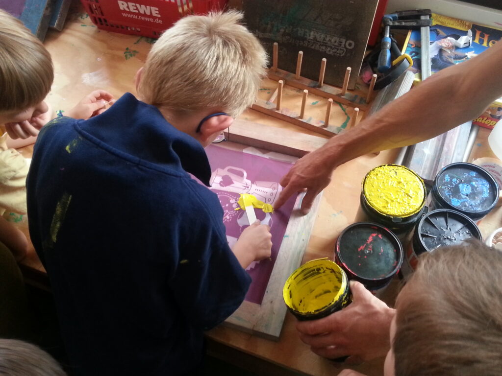 Kinder beim kreativen Malen mit bunten Farbtöpfen